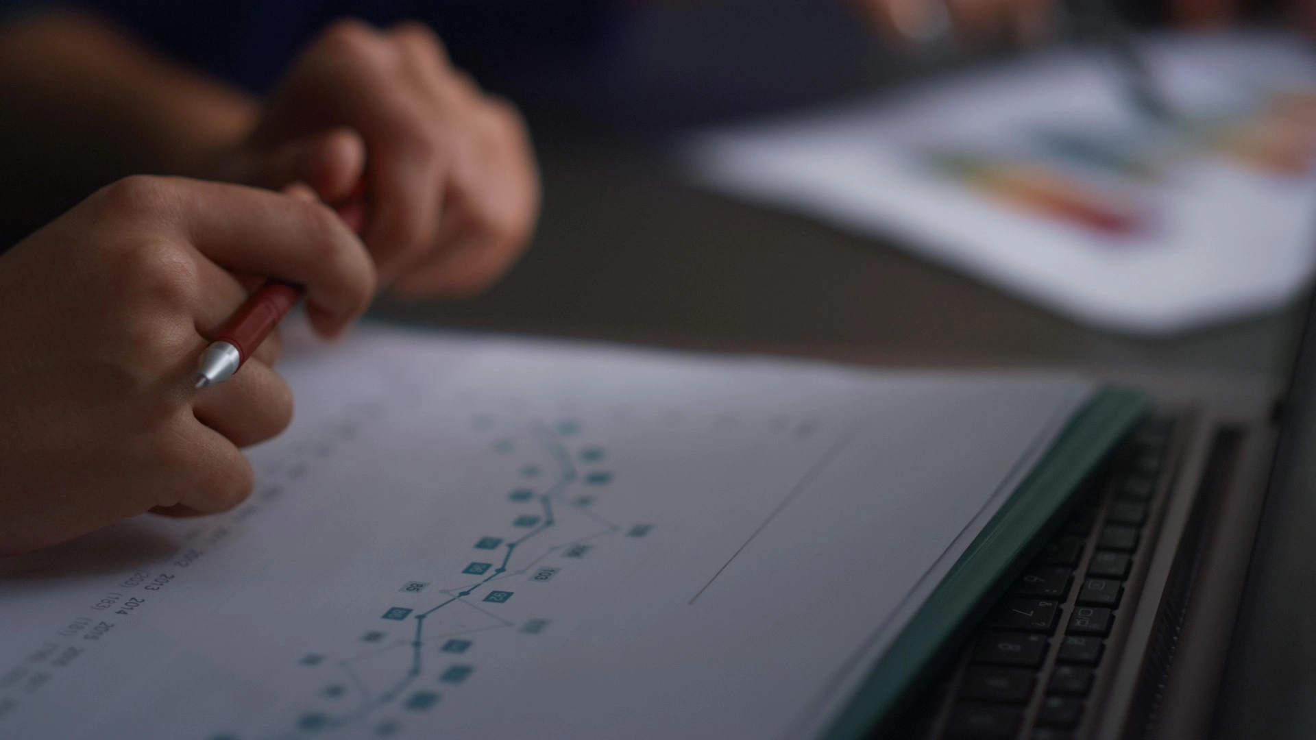 Hands writing on digital charts